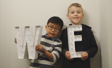 kids with lighted letters w, e