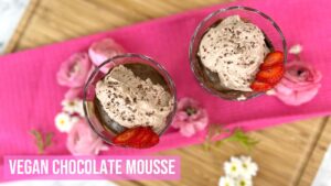 Vegan Chocolate Mousse in glass cups topped with chocolate coconut whipped cream and strawberries