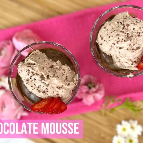 Vegan Chocolate Mousse in glass cups topped with chocolate coconut whipped cream and strawberries